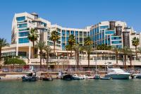 ein großes Gebäude mit Palmen und Booten im Wasser in der Unterkunft U Magic Palace in Eilat