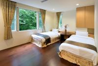 two beds in a room with a large window at Sun Moon Lake Karuizawa Villa in Yuchi