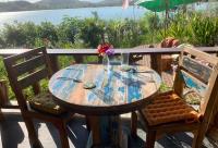 une table en bois avec deux chaises et une table avec vue sur l'eau dans l'établissement Lombok Villas, Villa PaoPao, à Labuhanpoh