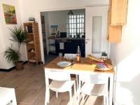 a kitchen with a wooden table with chairs and a dining room at Ty Gavrinis - T2- Centre Bourg - 100m de la mer in Larmor-Baden