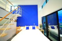 a bedroom with a blue wall and a bed with blue pillows at Qixingtan Xinghai B&amp;B in Dahan