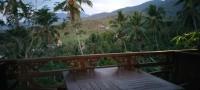 a wooden balcony with a view of a mountain at D'kailash Retreat in Singaraja