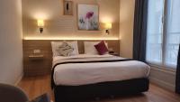 a hotel room with a large bed with pillows at Magda Champs Elysées in Paris