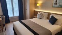 a bedroom with a large bed with blue and white pillows at Magda Champs Elysées in Paris