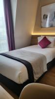 a hotel room with a large white bed with red pillows at Magda Champs Elysées in Paris