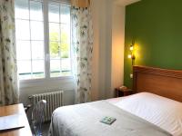 a bedroom with a bed and a window at Logis Hôtel-Restaurant Les Airelles in Neufchâtel-en-Bray