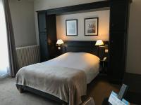 a hotel room with a large bed with two lamps at Logis Hôtel-Restaurant Les Airelles in Neufchâtel-en-Bray