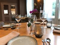 a wooden table with wine glasses on top of it at Logis Hôtel-Restaurant Les Airelles in Neufchâtel-en-Bray