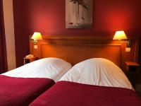 a bedroom with a bed with two white pillows at Logis Hôtel-Restaurant Les Airelles in Neufchâtel-en-Bray