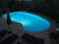 a large blue swimming pool with chairs and an umbrella at Maison de 2 chambres avec piscine privee jardin amenage et wifi a Bruniquel in Bruniquel