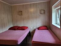 two beds in a room with red and pink sheets at STUDIO ENTRE PARIS et DISNEY 3 in Torcy
