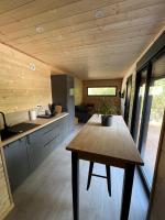 a kitchen with a wooden ceiling and a wooden table at Chalet 1 contemporain dans son écrin de verdure in Montauban