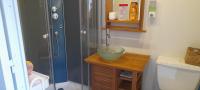 a bathroom with a shower and a bowl on a table at Gîte de charme avec jacuzzi étang babyfoot et rivière 
