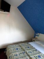 a bed in a room with a blue wall at Hotel De France in Pontorson
