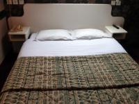 a bed with white sheets and pillows in a bedroom at Hotel De France in Pontorson