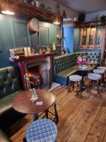 Un restaurante con mesas y sillas y una chimenea. en The Rhu Inn, en Rhu