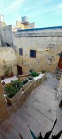 a courtyard with some plants and a building at Ta Majsi farmhouse with indoor heated pool in San Lawrenz