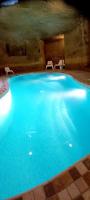 a large blue swimming pool in a cave at Ta Majsi farmhouse with indoor heated pool in San Lawrenz