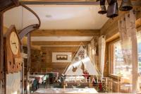 a restaurant with a clock and tables in a room at Alpen Chalet - Charme Mountain Hotel - in Schilpario