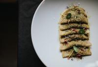 a white plate with a piece of food on it at Presulis Hideaway Apartments & Restaurant in Fiè