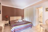 a bedroom with a bed with a colorful striped blanket at VILLA LE MAS D&#39;AZUR BY ESTATESCANNES in Vallauris