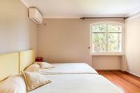 two beds in a room with a window at VILLA LE MAS D&#39;AZUR BY ESTATESCANNES in Vallauris