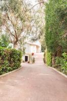 a driveway with trees and a house in the distance at VILLA LE MAS D&#39;AZUR BY ESTATESCANNES in Vallauris