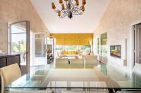 a dining room with a glass table and a living room at VILLA LE MAS D&#39;AZUR BY ESTATESCANNES in Vallauris