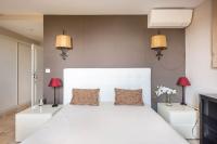 a bedroom with a large white bed with two lamps at VILLA LE MAS D&#39;AZUR BY ESTATESCANNES in Vallauris