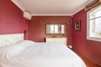 a red bedroom with a white bed and a window at VILLA LE MAS D&#39;AZUR BY ESTATESCANNES in Vallauris