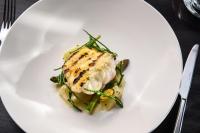 a white plate with a piece of fish and asparagus at Castlemartyr Resort Hotel in Castlemartyr