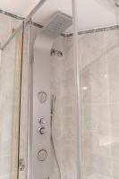 a shower stall with a glass door and a shower constructor at Casa Rural Las Cuevas de Setenil in Setenil
