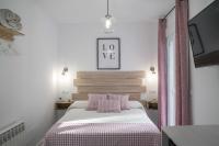 a bedroom with a bed with a pink and white blanket at Casa Rural Las Cuevas de Setenil in Setenil
