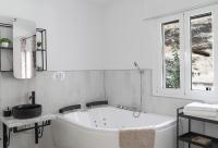 a white bathroom with a tub and a window at Casa Rural Las Cuevas de Setenil in Setenil