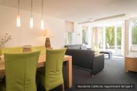 a living room with a table and a couch at Residentie Californië in De Koog