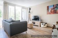 a living room with a couch and a tv at Residentie Californië in De Koog