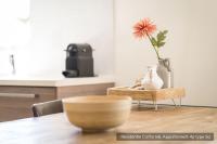 a wooden table with a vase and a flower on it at Residentie Californië in De Koog