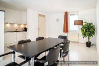 a dining room with a black table and chairs at Residentie Californië in De Koog