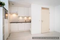 a white kitchen with white cabinets and a sink at Residentie Californië in De Koog