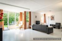 a living room with a couch and a tv at Residentie Californië in De Koog