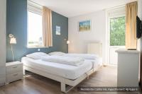 two beds in a bedroom with blue walls at Residentie Californië in De Koog