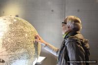 a woman is pointing at a map on a globe at Residentie Californië in De Koog