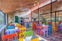 a brightly colored restaurant with tables and chairs at THE CEDAR CASTLE in Mukteswar