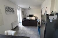 a living room with a black refrigerator and a couch at Studio entre Clohars Carnoet et Doelan in Clohars-Carnoët