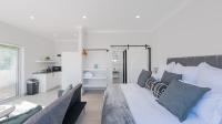 sala de estar con cama grande con almohadas azules en 34.4 Degrees South Studio Apartment, en Agulhas