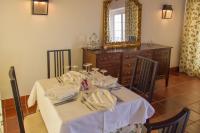 a dining room table with a white table cloth and a mirror at Hotel Rural Monte da Provença in Elvas