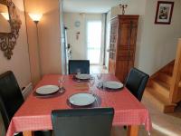 a dining room table with a red table cloth and chairs at Holiday home with sea views, Plounéour-Brignogan-Plages in Plounéour-Trez