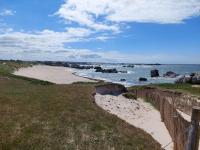 a sandy beach with a fence and the ocean at Holiday home with sea views, Plounéour-Brignogan-Plages in Plounéour-Trez