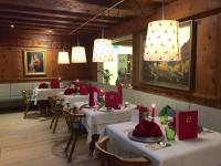 a dining room with tables with red napkins and candles at Impuls Hotel Tirol in Bad Hofgastein