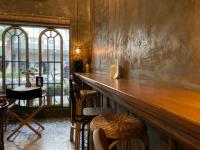 a bar with a wooden counter and some chairs at Central Old Town Cottage in Bangkok